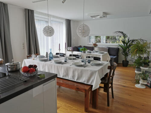 Großer Esstisch für 8, dahinter kleiner für 4 Personen